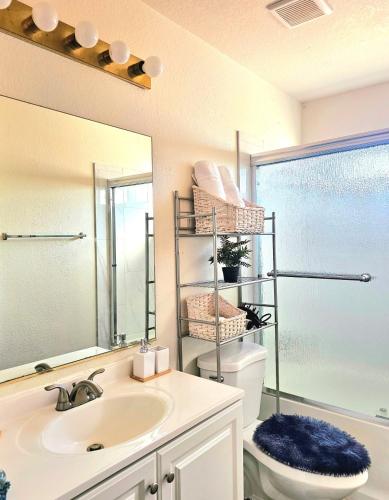 a bathroom with a sink and a toilet and a mirror at Nice Private Room in a House Close to Red Rock & Las Vegas Strip #1 in Las Vegas