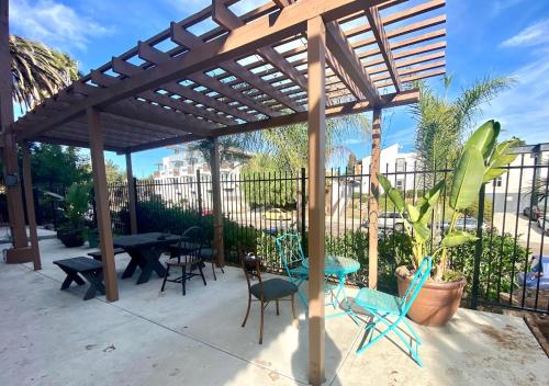 pérgola de madera con mesas y sillas en el patio en Bright & Quiet 1-Bed Condo with Balcony, en San Diego