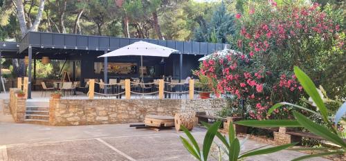 a restaurant with a table and an umbrella and flowers at Bungalow comfort 100 m from the Beach in Premantura