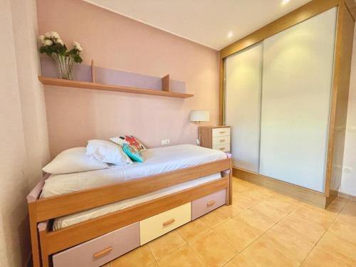 a small bedroom with a bed and a mirror at Planta baja en pleno centro de la playa in Moncófar