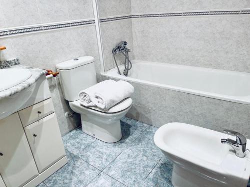 a bathroom with a toilet and a sink and a bath tub at Planta baja en pleno centro de la playa in Moncófar