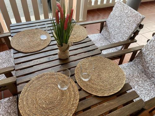 a wooden table with two straw hats and two chairs at Planta baja en pleno centro de la playa in Moncófar
