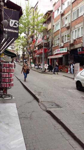 a woman walking down a street in a city at Hotel Cesmeli in Bursa