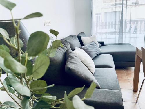 a blue couch in a living room with a plant at Planta baja en pleno centro de la playa in Moncófar