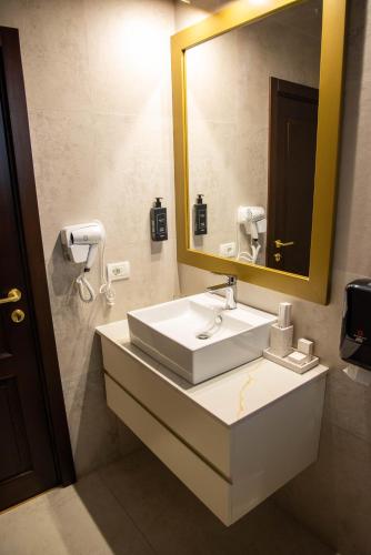 a bathroom with a sink and a large mirror at Zestrea Maramureșului Săpânța in Săpînţa