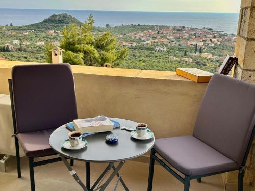 two chairs and a table with two cups of coffee at Horizon Villa Mani - Seaview Family Friendly House in Stoupa