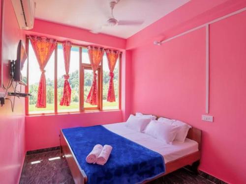a bedroom with pink walls and a bed with flip flops at ANIBESH HOTEL in Havelock Island