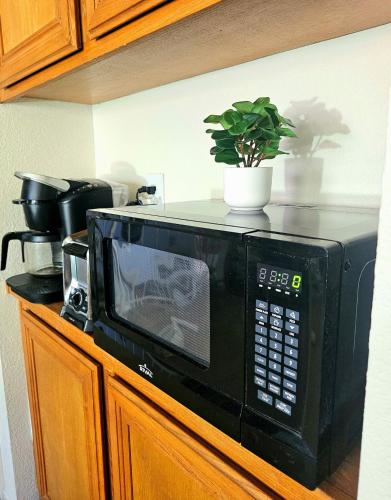 a black microwave sitting on top of a counter at Nice Private Room in a House Close to Red Rock & Las Vegas Strip #1 in Las Vegas