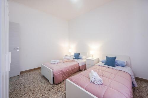2 Betten in einem Zimmer mit rosa und blauen Kissen in der Unterkunft Smart Stay near Policlinico & City Center in Modena