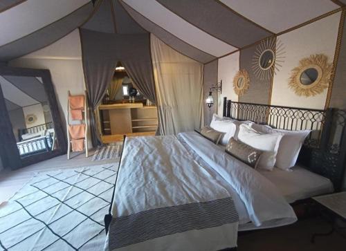 a bedroom with a large bed in a room at Sandrela Luxury Camp in Merzouga