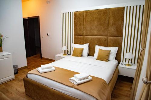 a bedroom with a large bed with two towels on it at Zestrea Maramureșului Săpânța in Săpînţa
