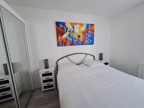 une chambre avec un lit blanc et un tableau au mur dans l'établissement Fun and quiet, à Paris