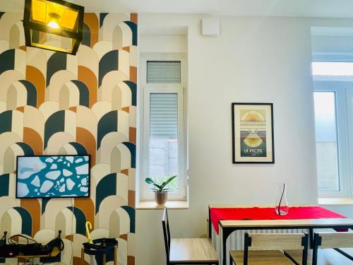 リールにあるCharming flat ideal location, 2 bedroom 5 pers maxの赤いテーブルと壁のあるリビングルーム