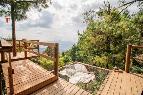 a wooden deck with a view of the mountains at Glamping, Jacuzzi, Malla Catamarán y Desayuno en Santa Elena in Medellín