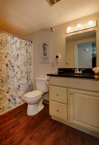 a bathroom with a toilet and a sink and a mirror at Misty Harbor Resort in Wells