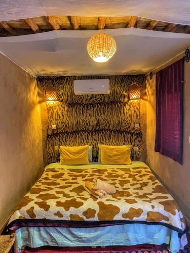 a bedroom with a cheetah print bed in a room at Riad La Perle Tamnougalte in Agdz
