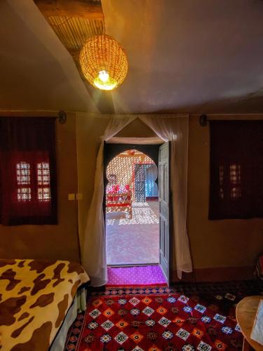 a room with a bed and a room with a doorway at Riad La Perle Tamnougalte in Agdz