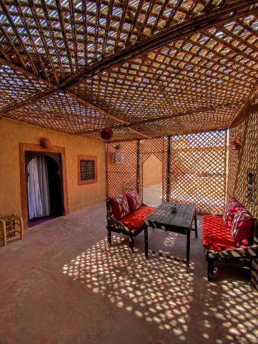 a room with two couches and a table in a building at Riad La Perle Tamnougalte in Agdz