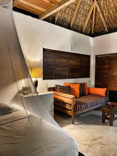 a living room with a couch and a bed at Cabañas Uma 1 in San Agustinillo