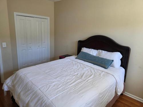 a bed with a blue pillow on top of it at Heaven on Earth - Large Bedroom with Private Bathroom in Raleigh