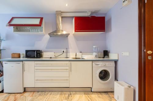 a kitchen with a sink and a washing machine at La Maresía in Cudillero