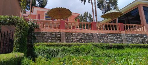 a house with two umbrellas on top of a wall at Paqariy lodge in Amantani