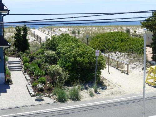 a garden with bushes and trees on the side of a street at Brant Beach Oceanside Pet Friendly Second Floor Duplex Ocean Views 14018 in Brant Beach