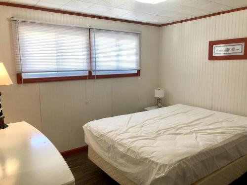a bedroom with a white bed and two windows at Brant Beach Oceanside Pet Friendly Second Floor Duplex Ocean Views 14018 in Brant Beach