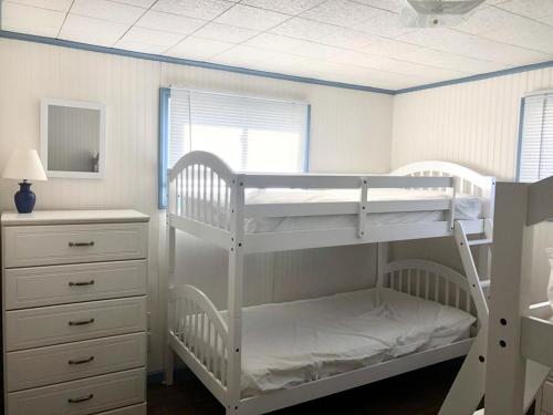 a bedroom with two bunk beds and a dresser at Brant Beach Oceanside Pet Friendly Second Floor Duplex Ocean Views 14018 in Brant Beach