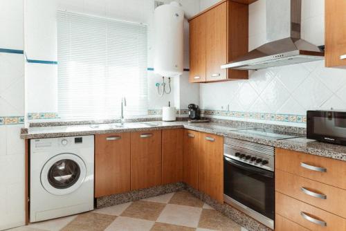 a kitchen with a washing machine and a washer at Rincón del Guadiana in Ayamonte