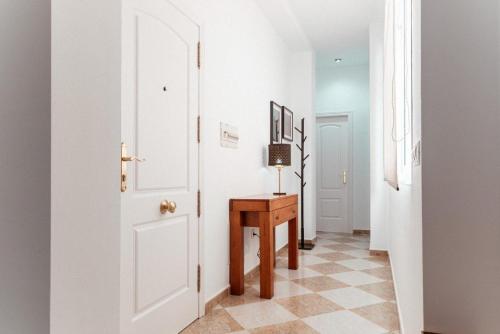 a hallway with a white door and a table at Rincón del Guadiana in Ayamonte