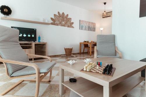 a living room with a chessboard on a table and two chairs at Rincón del Guadiana in Ayamonte