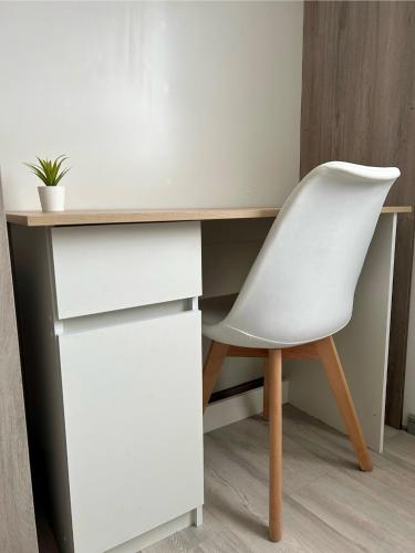 a white desk with a white chair in a room at Hostal Chucaita Puerto Cisnes in Puerto Cisnes
