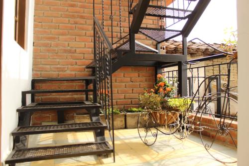 a black spiral staircase next to a brick wall at LAMACA - Hotel & Restaurante in Buga