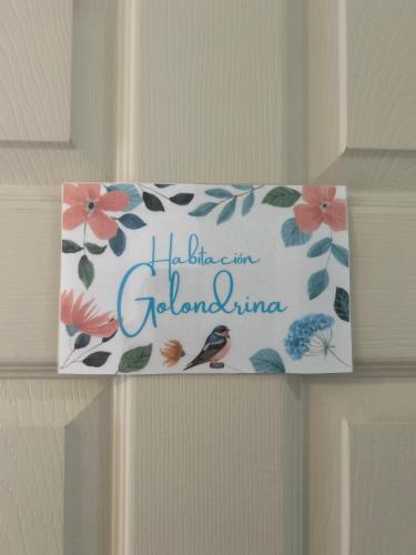 a sign on a door with flowers and a bird at Hostal Chucaita Puerto Cisnes in Puerto Cisnes