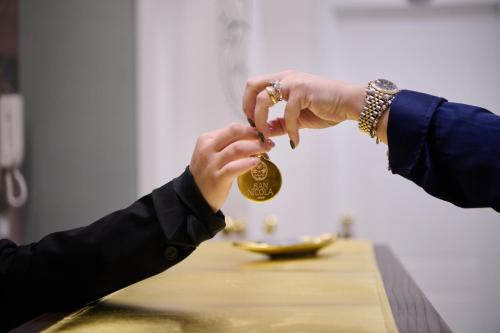 two people are holding a coin in their hands at San Nicola Rooms Siracusa in Siracusa