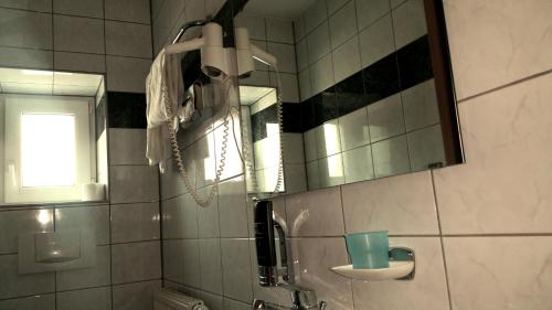 baño con espejo y teléfono en la pared en Hotel Al Cavallino en Arnstorf