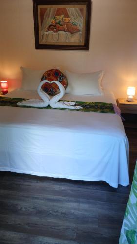a bedroom with a white bed with two towels on it at Niihau Lodge in Orufara