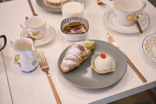 a table with a plate with a pastry on it at San Nicola Rooms Siracusa in Siracusa
