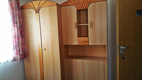 a closet with wooden cabinets in a room at Hotel Al Cavallino in Arnstorf