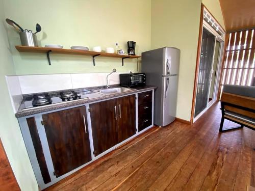 a kitchen with a stainless steel refrigerator and a sink at Casa MILUCO Maison privée vue sur mer in Puerto Viejo