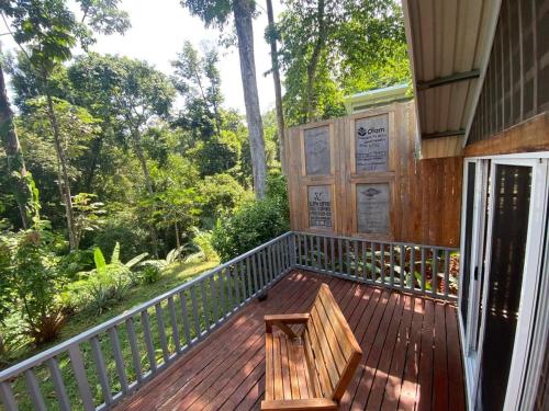 a wooden deck with a bench on the side of a house at Casa MILUCO Maison privée vue sur mer in Puerto Viejo