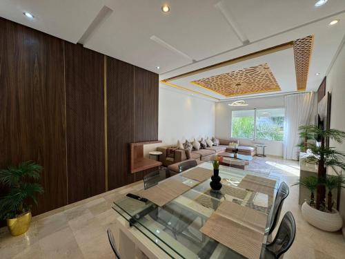 a living room with a glass table and a couch at Appartement Luxueux Casa Nearshore in Casablanca