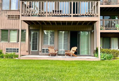 zwei Stühle auf der Veranda eines Gebäudes in der Unterkunft Charming 1BDR Condo w Spectacular Golf Course View - 5518 in Traverse City