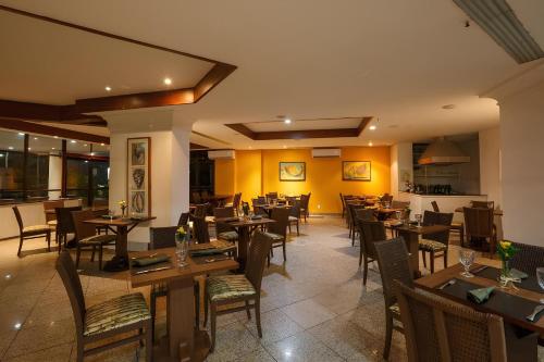 a dining room with wooden tables and chairs at Flat Particular em Blue Tree Towers Beira Mar Fortaleza in Fortaleza
