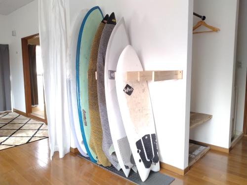 a row of surfboards hanging on a wall at ナガエベース in Hyuga