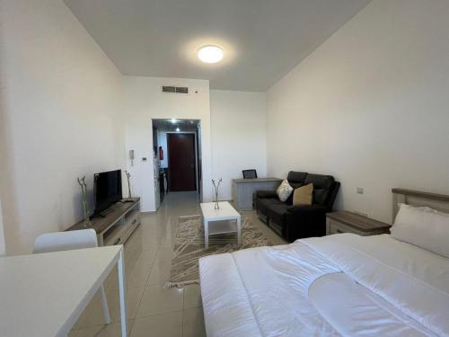 a bedroom with a bed and a living room with a couch at Sweet Home Lagoon View in Ras al Khaimah