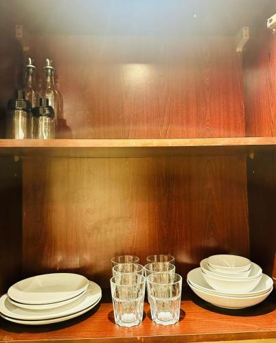 a table with plates and glasses on a shelf at Sweet Home Lagoon View in Ras al Khaimah