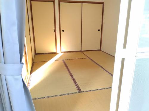an open door to a room with a closet at ナガエベース in Hyuga