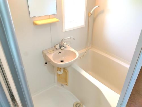 a bathroom with a sink and a bath tub at ナガエベース in Hyuga